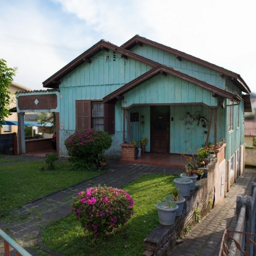 Casa antiga simples de tábua com varanda frontal