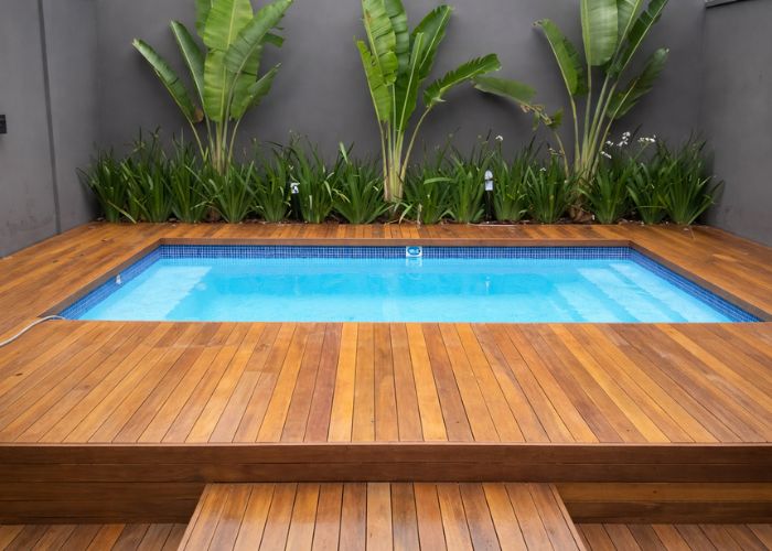 Piscina com deck elevado com acabamento em madeira que destaca conforto e beleza