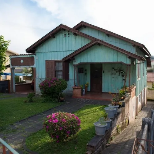 Casa antiga simples de tábua com varanda frontal