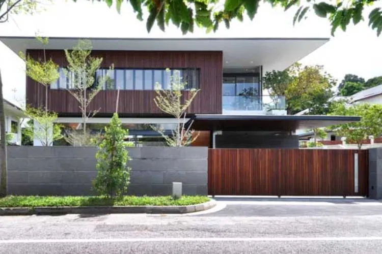 Combinação elegante de base em concreto e portão de madeira, unindo segurança e um visual acolhedor.Muro com portão de madeira